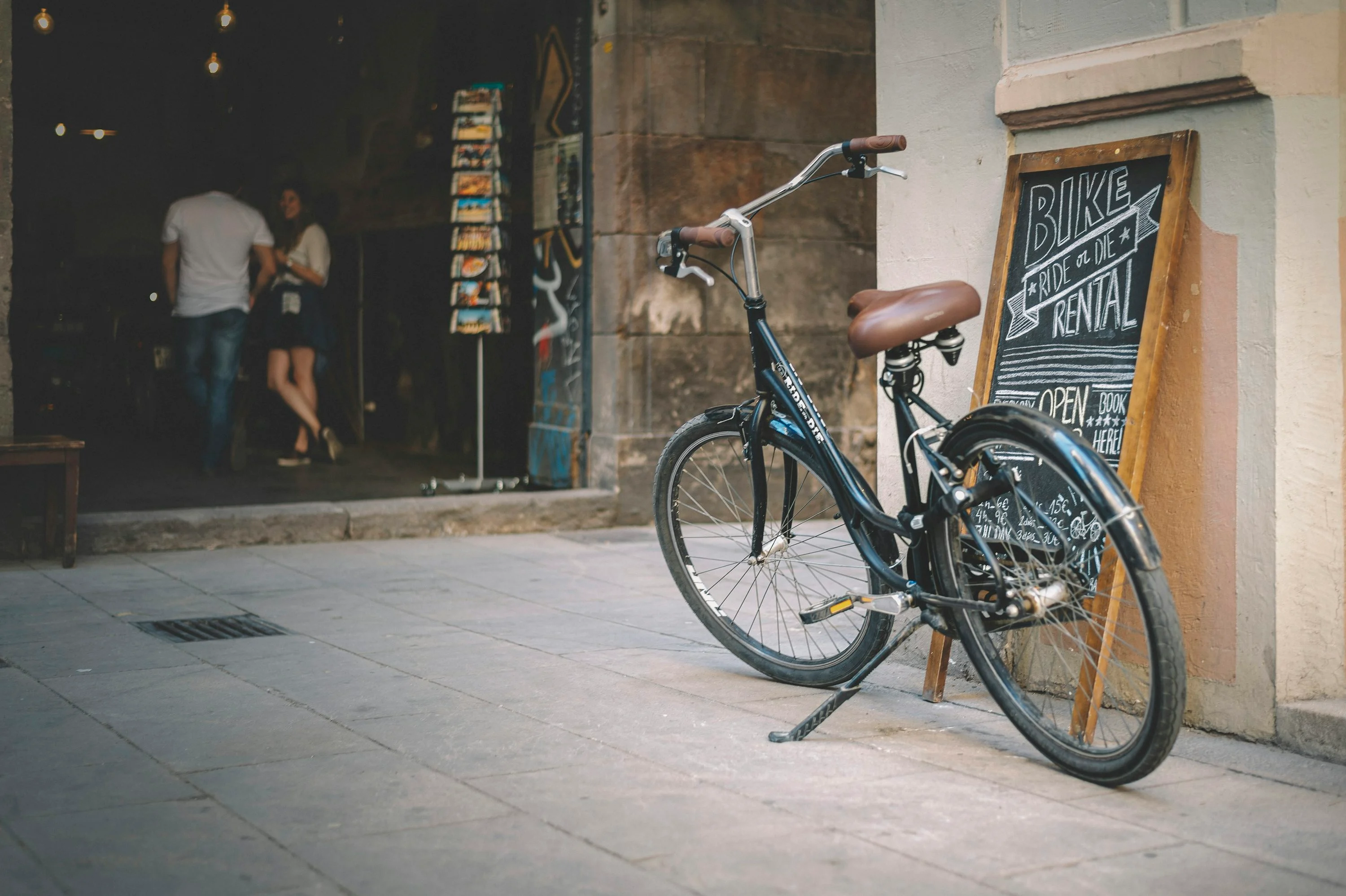 black city bike parked beside brown concrete building during daytime