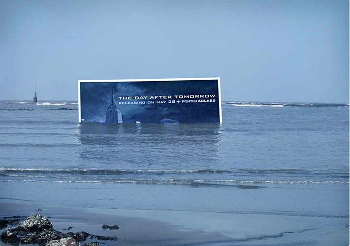A partially submerged billboard in the ocean advertising the disaster movie "The Day After Tomorrow".