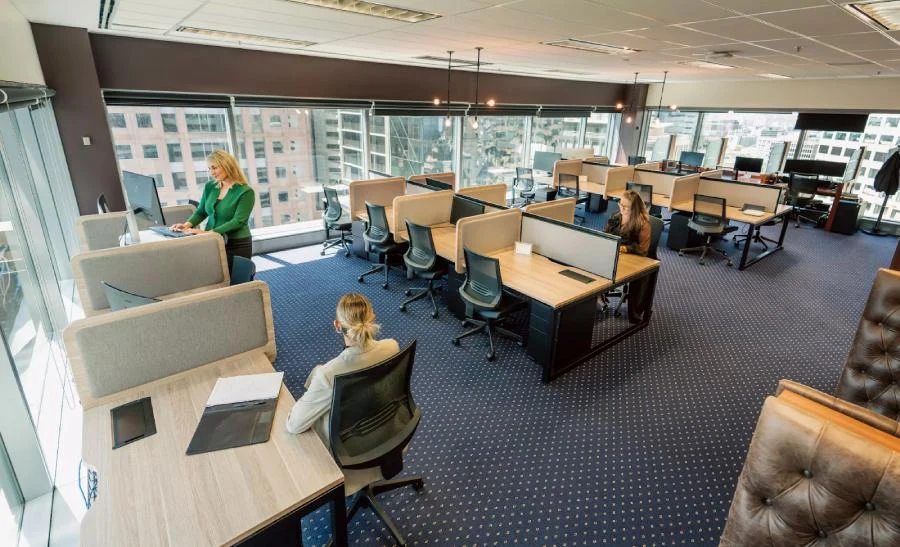 A Servcorp office space with multiple dedicated desks, ergonomic chairs, and desktop monitors.